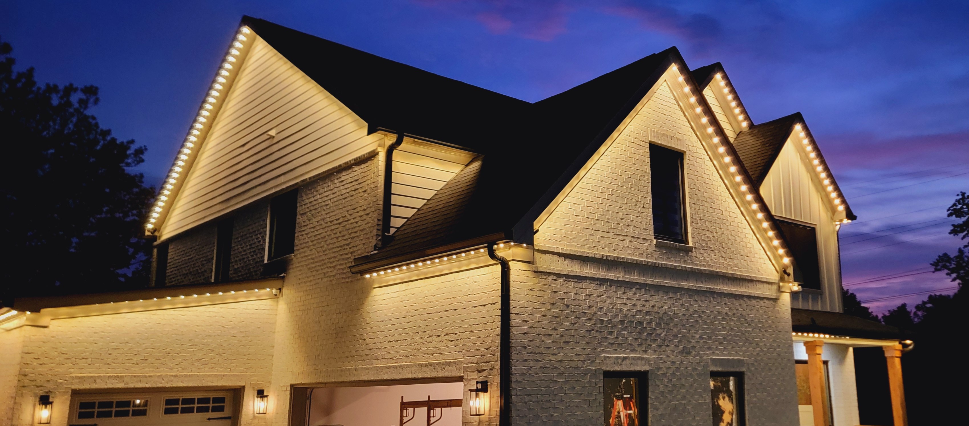 Home roofline illuminated with permanent warm white lights